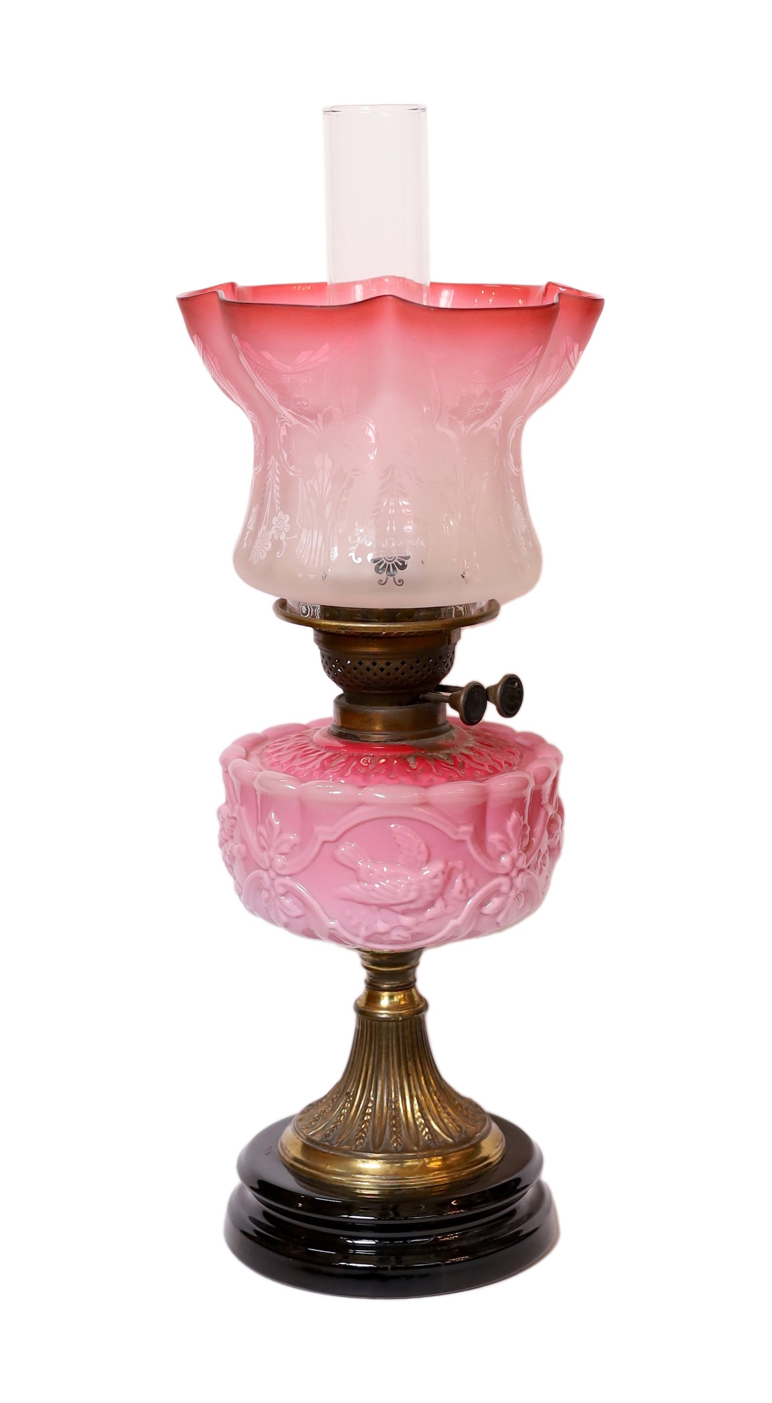 A late Victorian brass and pink opaque glass oil lamp with tinted frosted shade, height overall 56cm